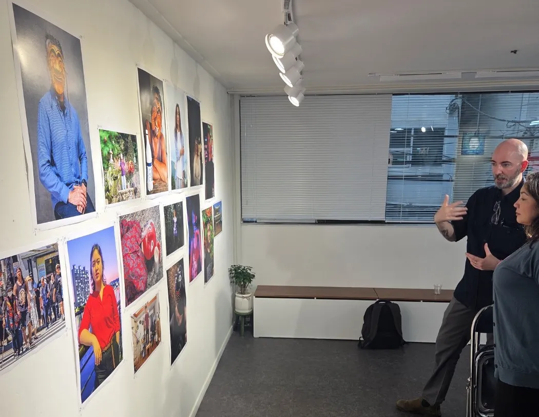 Niall Ruddy discusses his photography with a visitor, exploring themes of Korean heritage, cultural identity, and belonging.