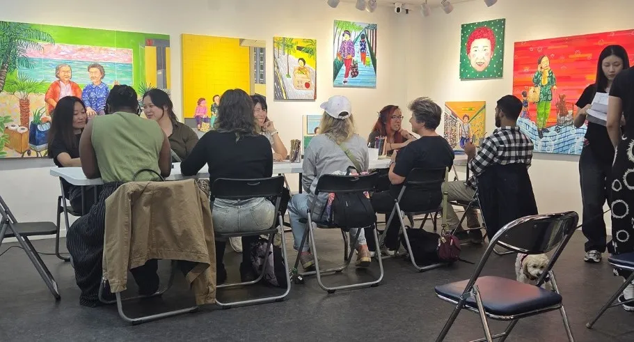 Audience members engage with the artists during the Between Faces discussion, highlighting the role of local galleries in fostering community connections.